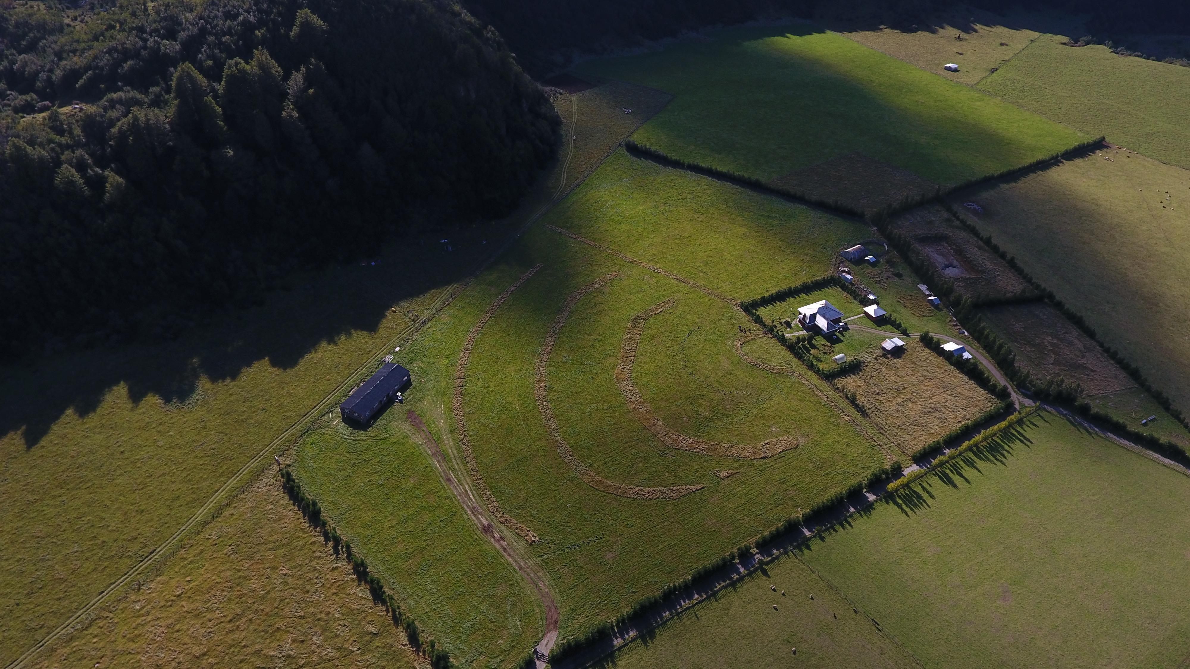 Vista cenital con drone del Fundo La Pampita — galpones, potreros y cortinas, Manihuales, Aysén
